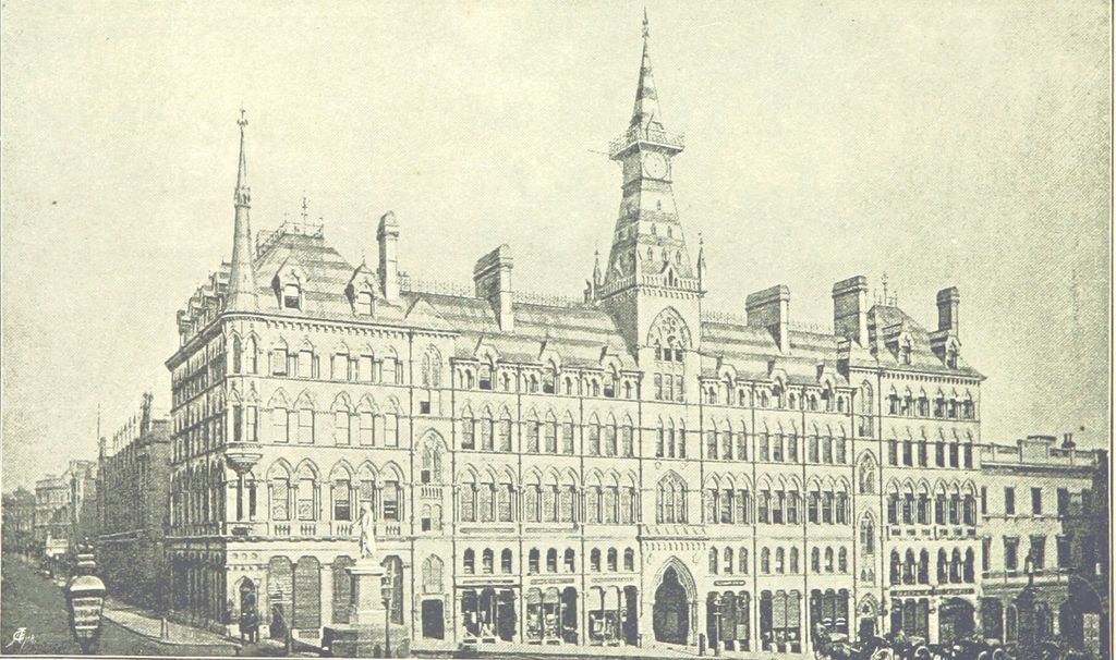 Engraving of a large Gothic stone building on a street corner with a central clock tower and spire, and a statue in front.