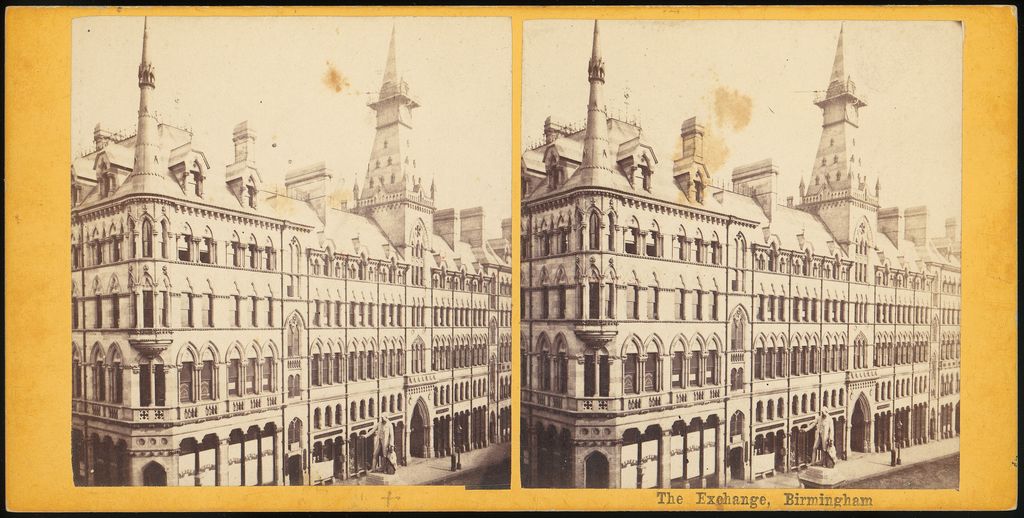 Victorian stereo photograph of a Gothic building with a corner spirelet and a clock tower with a spire.