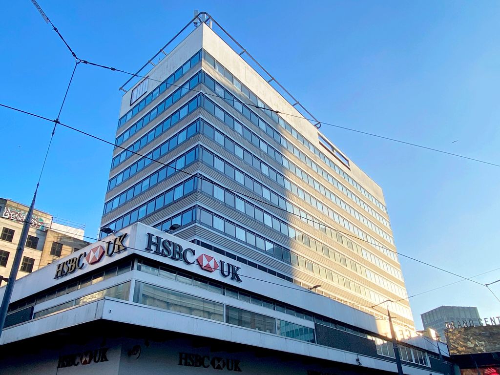 A 1960s concrete office block on a city street corner.