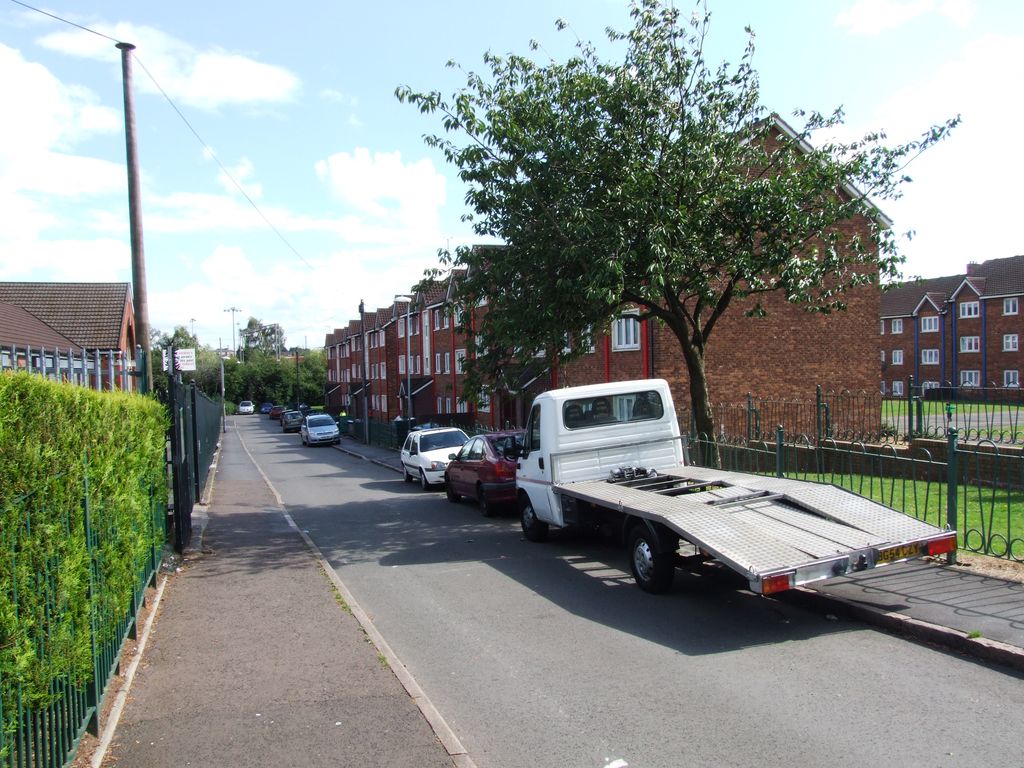 A quiet residential street of modern houses with a street sign reading Vauxhall Grove.