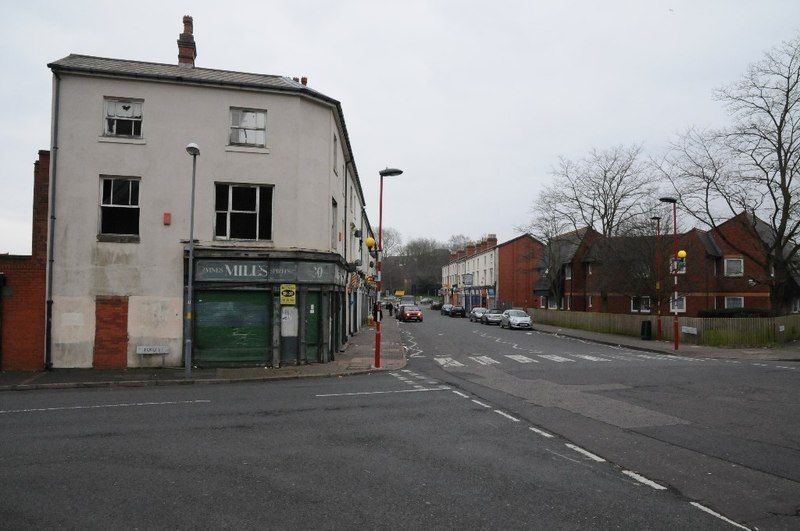A run-down brick industrial building on a city street.