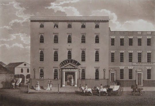 Engraving of a tall, plain four-storey Georgian building with ‘HOTEL’ over its doorway and carriages in front.