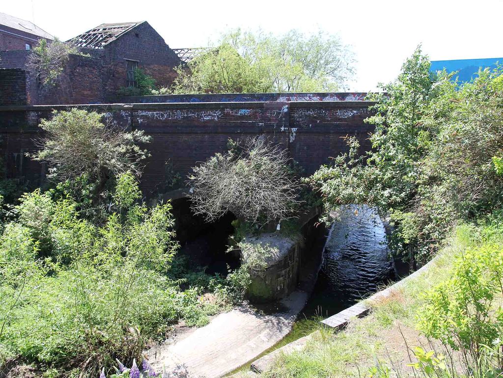 A canal aqueduct carrying the canal over a river in a brick channel.