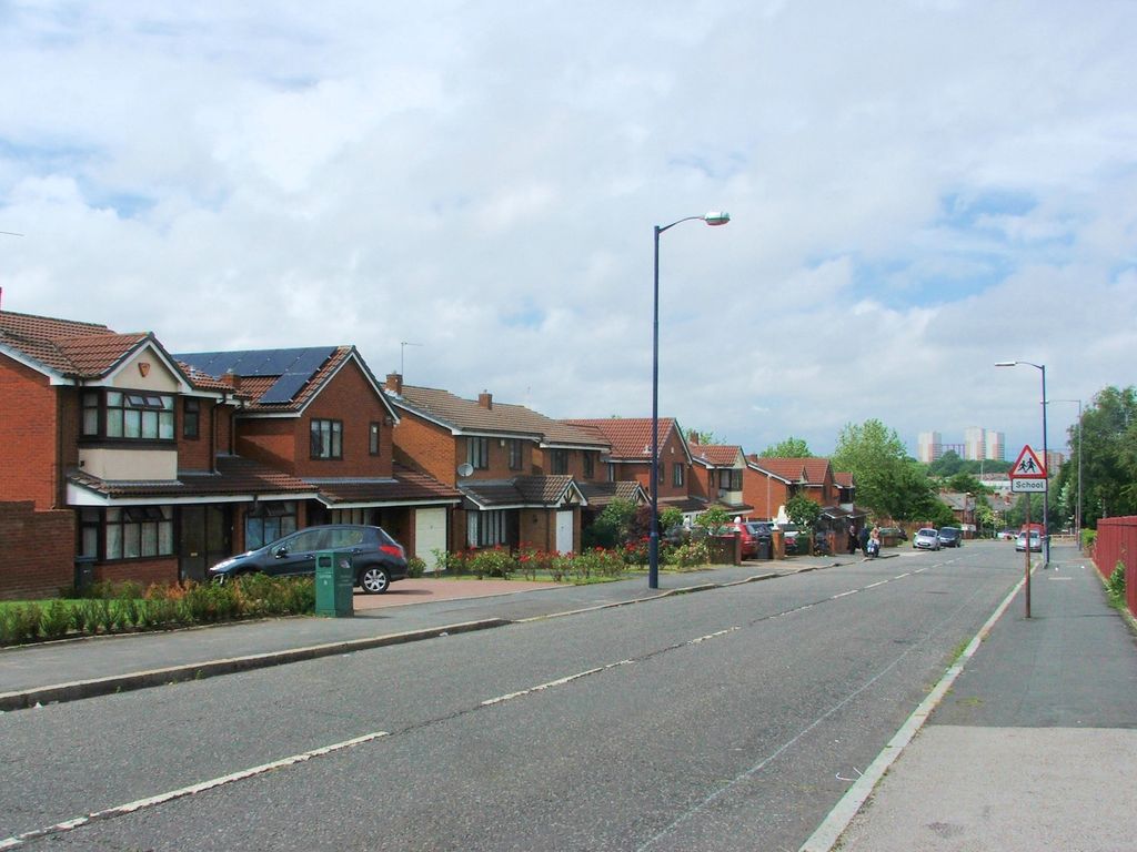 A quiet street of industrial buildings near a football ground.