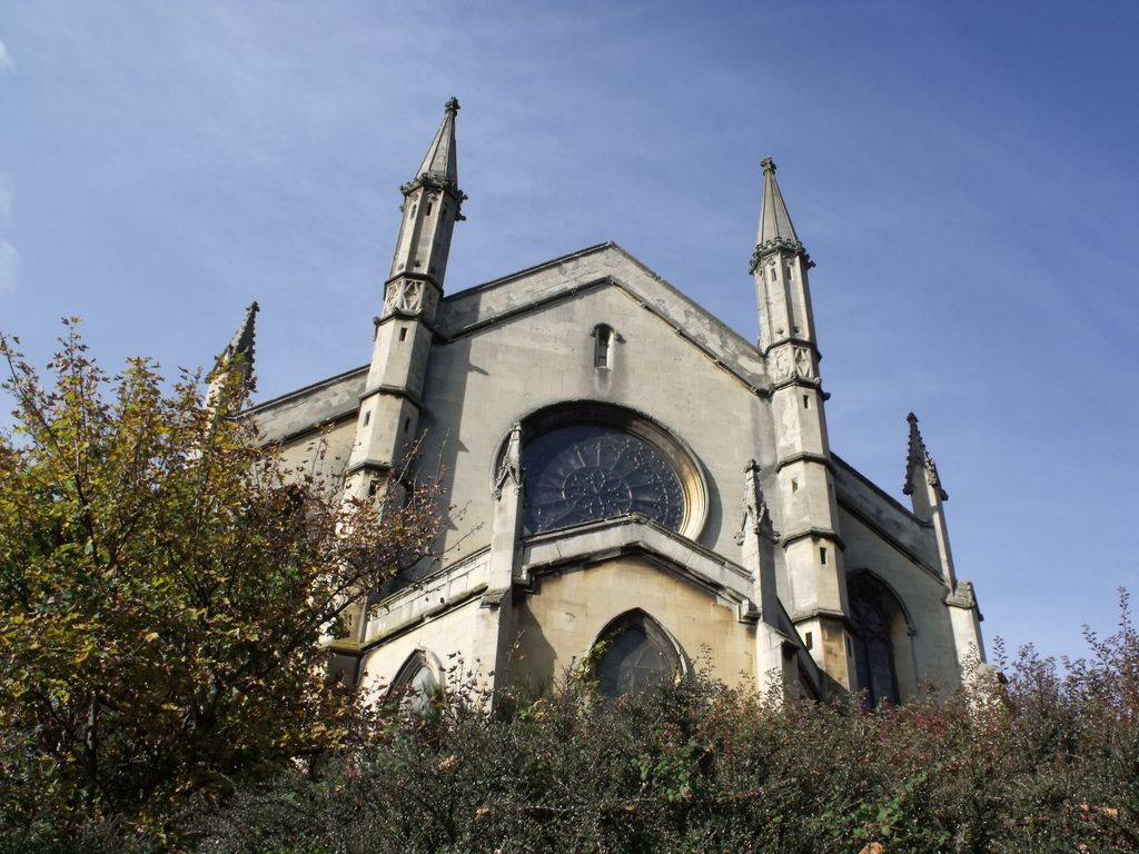 The east end of a Gothic church with a rose window between two slender pinnacled turrets.
