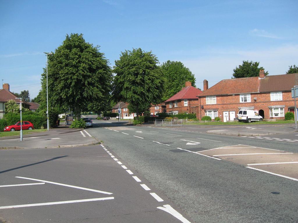Witton Lodge Road at its junction with Dovedale Road in July 2014, with red-brick estate houses and large trees